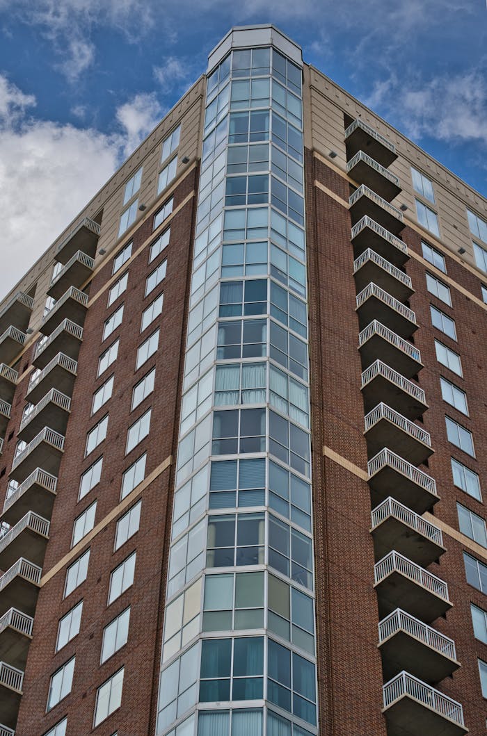 Low angle view of a modern high-rise apartment building in Atlanta against a clear blue sky.